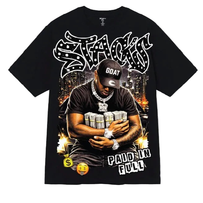 A black short-sleeve graphic t-shirt featuring a large front print of a man holding stacks of cash, with stylized white text reading 'STACK' and 'PAID IN FULL' on a light gray background.