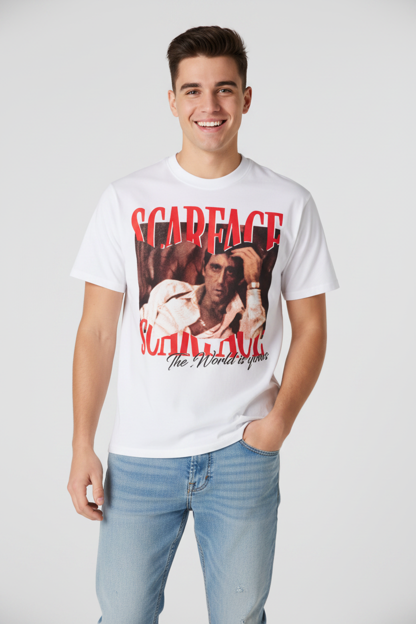 A white short-sleeve graphic t-shirt featuring a large red and black print of Scarface with the text 'SCARFACE' and 'The World is yours', modeled on a person against a light gray background.