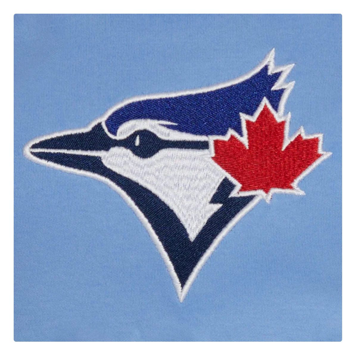 An embroidered patch of the Toronto Blue Jays logo, featuring a blue jay head with a red maple leaf accent on a light blue background.